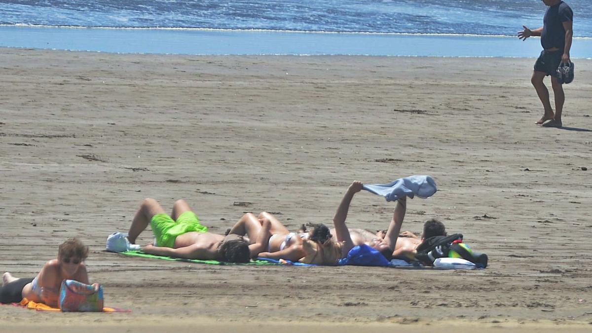 Un grupo de personas tomando el sol y paseando por la playa de Maspalomas. | | JOSÉ CARLOS GUERRA