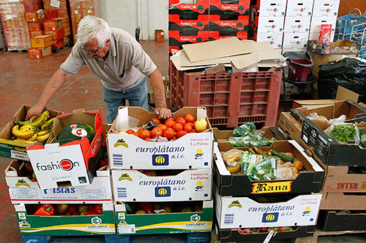 Un voluntari de l’oenagé ’Banc dels Aliments’, que té previst distribuir 5 milions de quilograms d’aliments el 2012, a la Pobla de Vallbona (València).