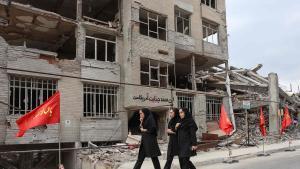 Tres mujeres caminan junto a un edificio residencial destruido por bombardeos de EEUU o Israel en Teherán, este lunes.