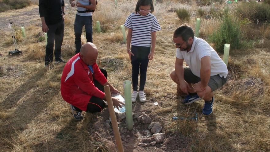 Una pequeña es ayudada por el edil Pedro Sosa y el alcalde, Diego José Mateos, a plantar un árbol. | PILAR WALS