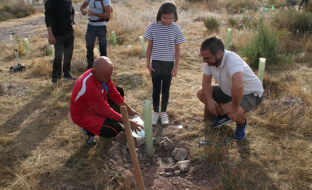 Una pequeña es ayudada por el edil Pedro Sosa y el alcalde, Diego José Mateos, a plantar un árbol. | PILAR WALS
