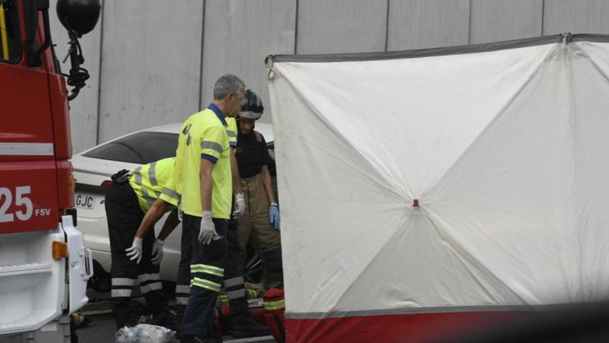 Bomberos trabajan para rescatar al hombre de su coche.