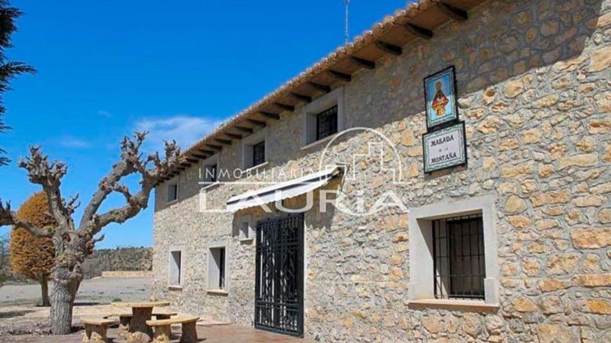 Fachada de piedra de la casa principal con vistas al pantano del Arquillo que está a la venta