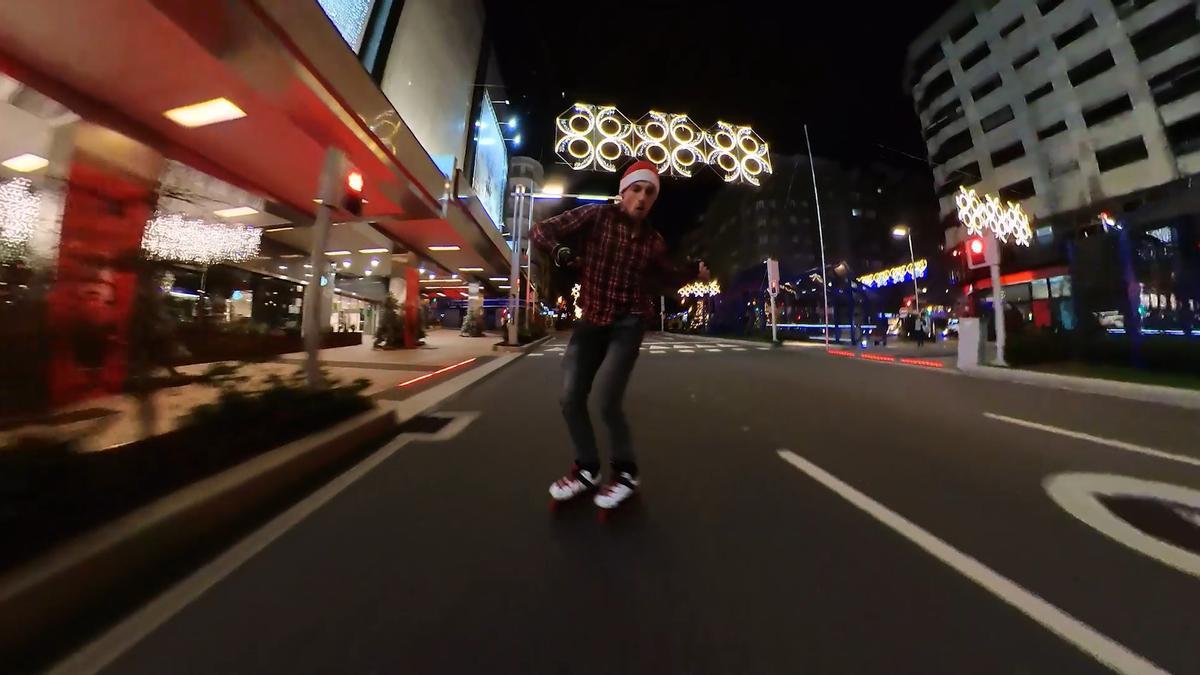 Matías Cioffi patinando por la Gran Vía de Vigo con las luces de Navidad encendidas.