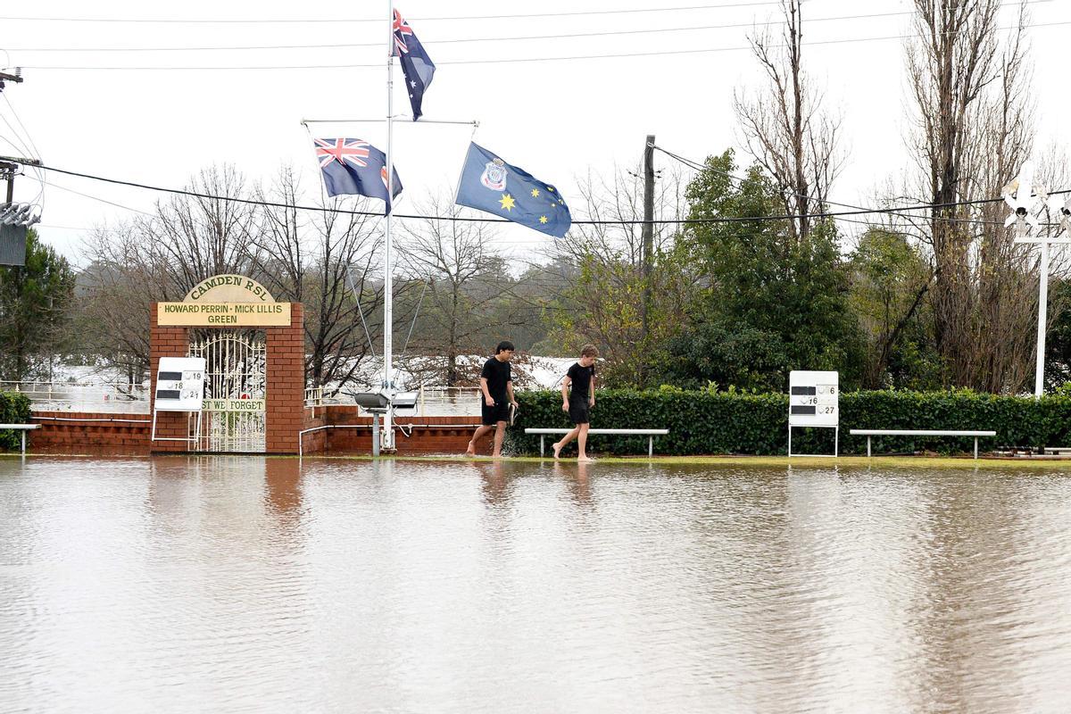 Los residentes se abren camino a través de las calles inundadas debido a las lluvias torrenciales en el suburbio de Camden en Sydney.