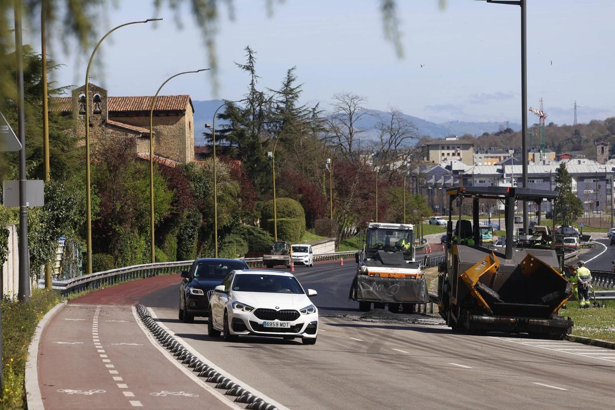 Máquinas y operarios trabajando este lunes en el pintado del nuevo carril bici que discurre junto a Santullano.