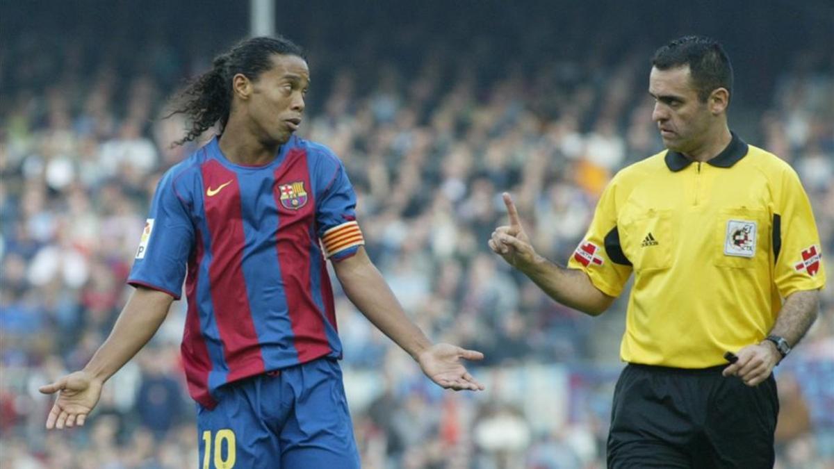 Pino Zamorano dialoga con Ronaldinho en un partido dirigido en el Camp Nou
