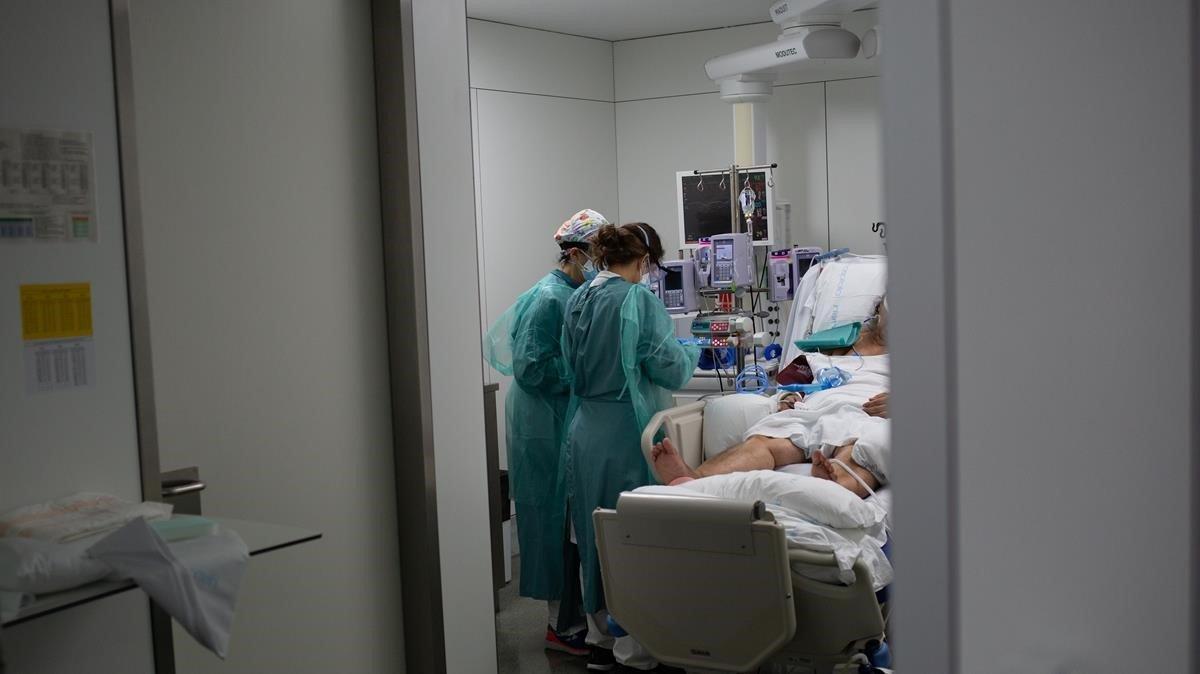 Personal sanitario visita a un enfermo ingresado en la uci del Hospital de la Santa Creu i Sant Pau de Barcelona, el pasado viernes.