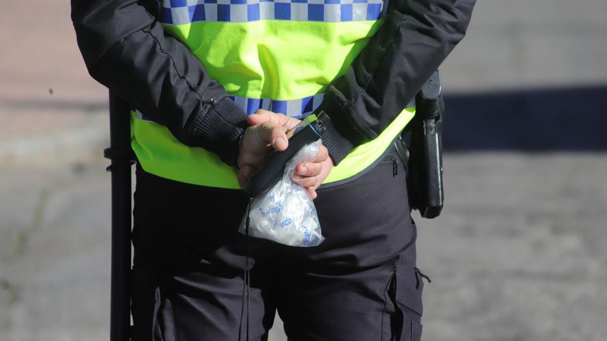 Un policía con una bolsa de boquillas para realizar controles de alcoholemia.