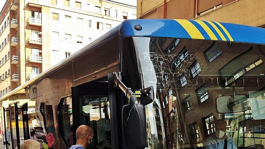 Dos viajeros, ayer, en una parada de La Felguera.