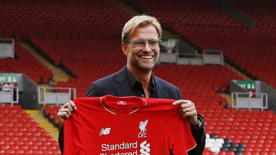 Klopp muestra la camiseta del Liverpool en Anfield. // Efe