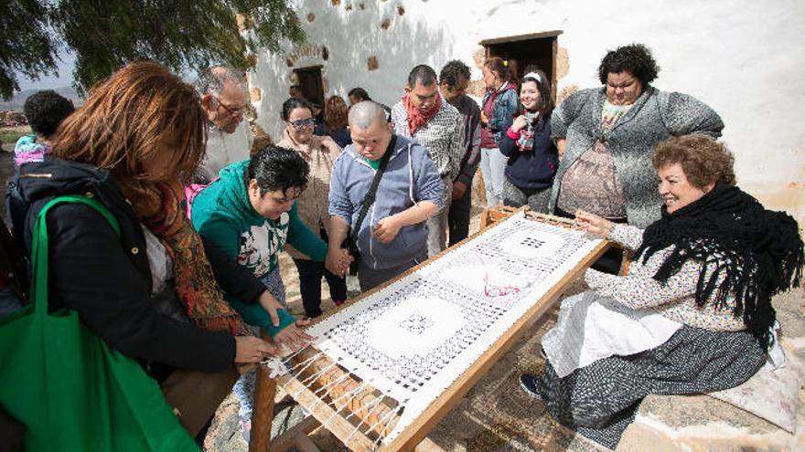 La caladora Nieves Rodríguez muestra sus trabajos de calado a los alumnos del Centro Ocupacional.