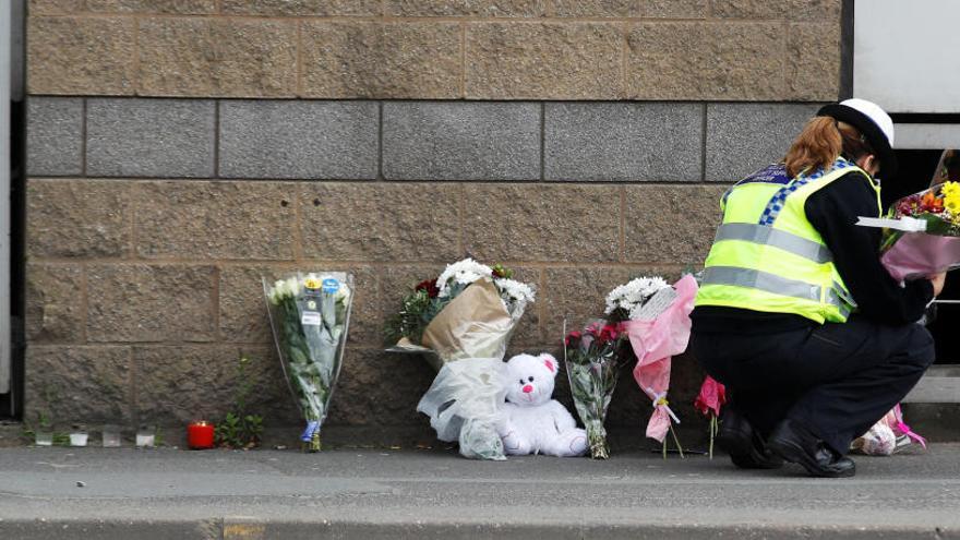 Un policía deja flores en homenaje a las víctimas de Mánchester