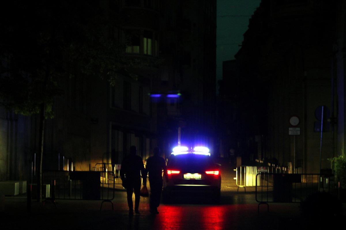 Una patrulla dels Mossos d'Esquadra circula pels porxos de la plaça Sant Joan de Lleida, a les fosques
