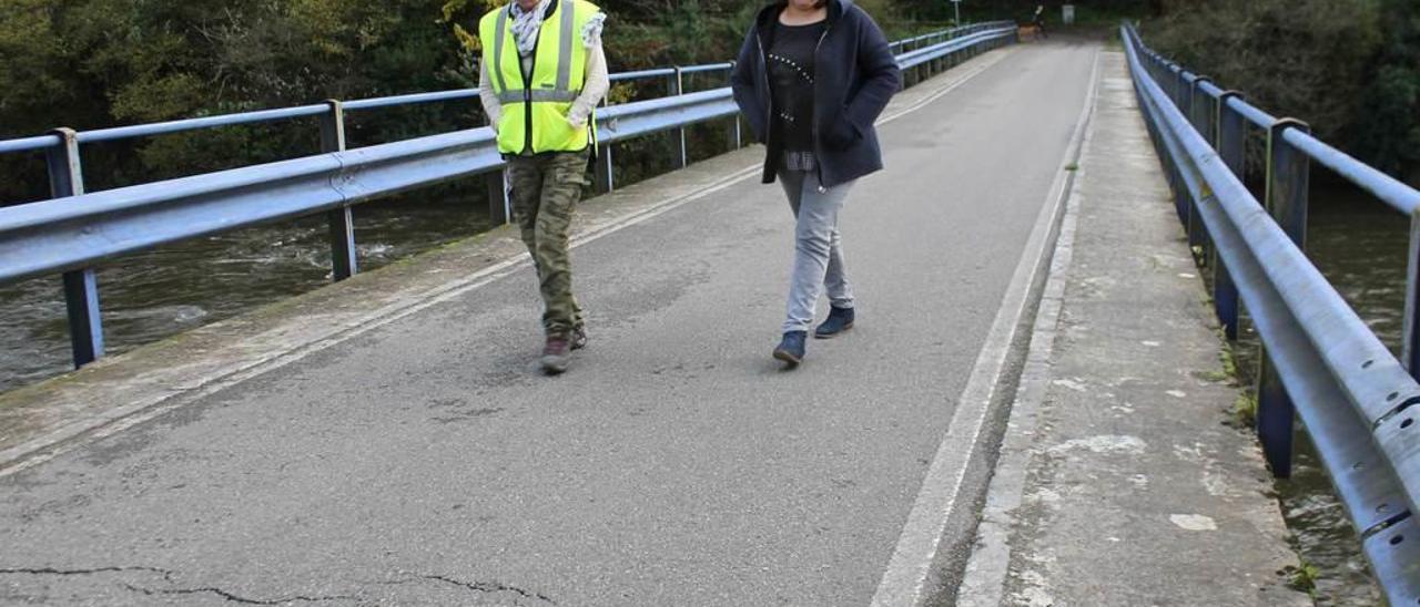 La ingeniera de caminos Ángeles Carazo y la concejala de Obras, Sonia Álvarez, ayer, examinando el estado del puente de Quinzanas (Pravia) .