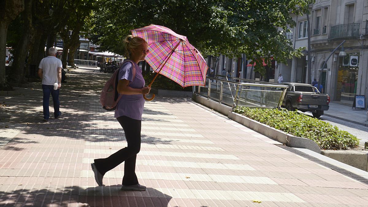 Una mujer camina por una calle en plena ola de calor.