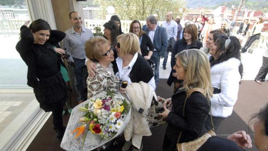 Pilar Rodríguez, con el ramo de flores, recibe las felicitaciones de los asistentes al homenaje.