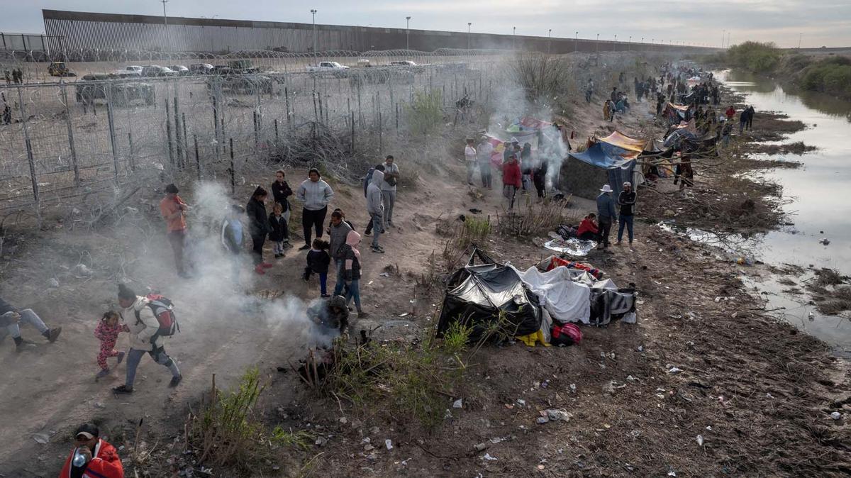 Migrantes acampan a lo largo de la orilla del río Grande mientras esperan entregarse a las autoridades de inmigración en El Paso, Texas, EE.UU