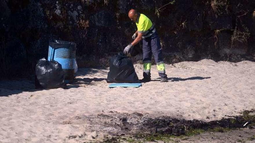 Los operarios de limpieza recogiendo en Canelas. // Noé Parga