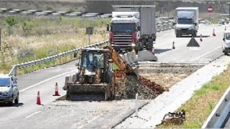 Màquines i operaris treballant en la reparació d&#039;un dels trams de l&#039;eix afectats, ahir al migdia