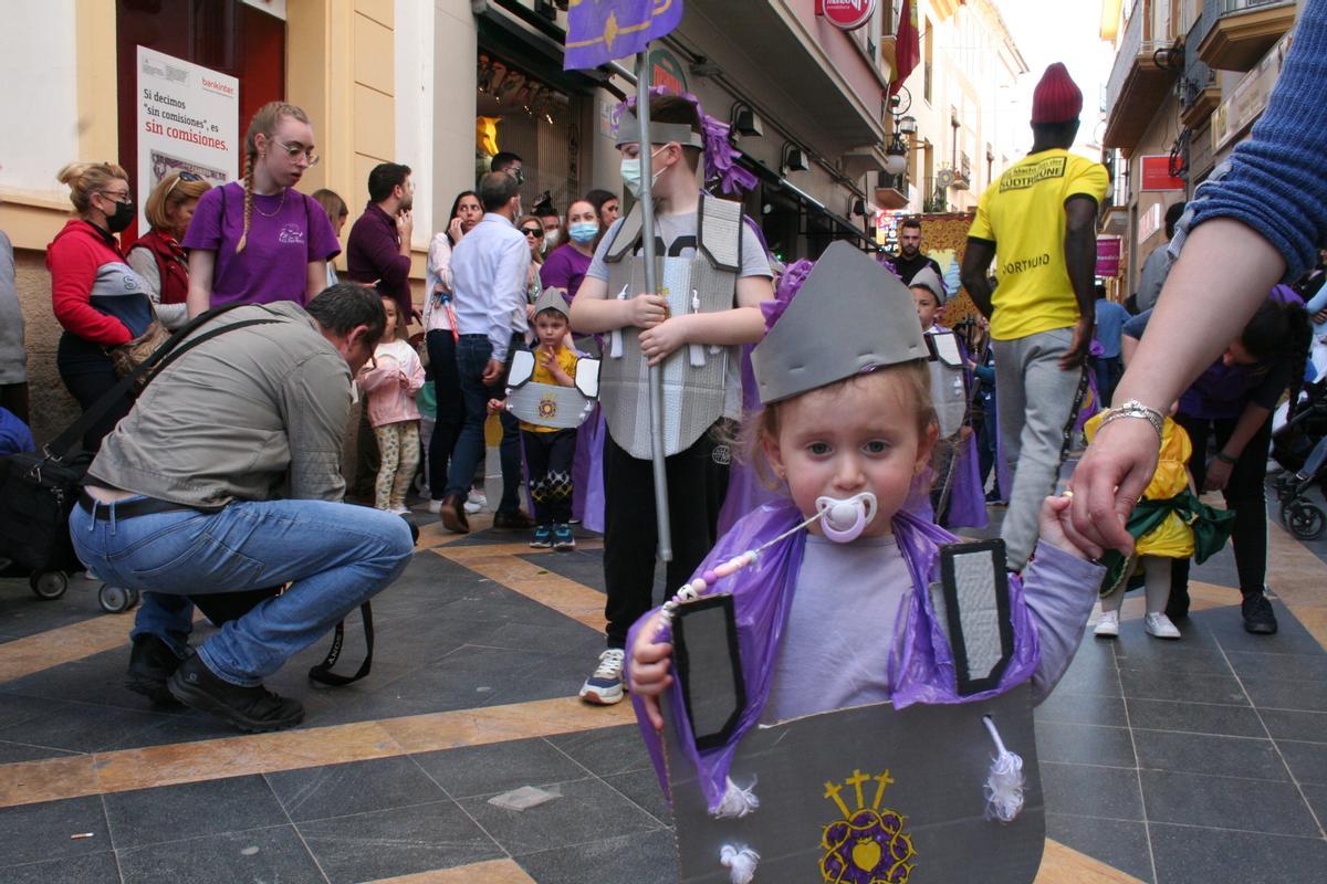 Una niña con chupete vestida de mayordomo anunciaba la llegada del cortejo del Paso Morado.