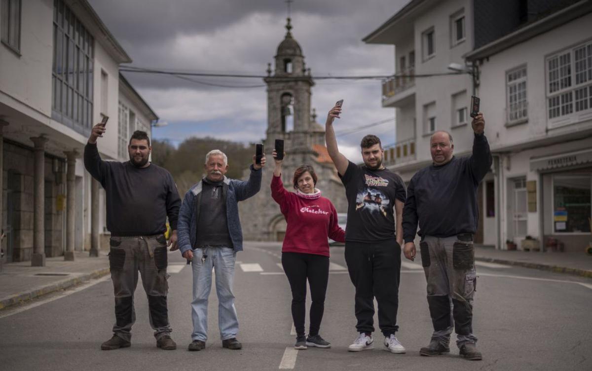 Un grupo de personas en San Xoán de Río, con el móvil en la mano.   | // BRAIS LORENZO