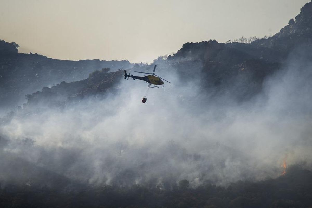 Un helicóptero trabaja sobre un incendio en la Sierra de Malagón (Ciudad Real).