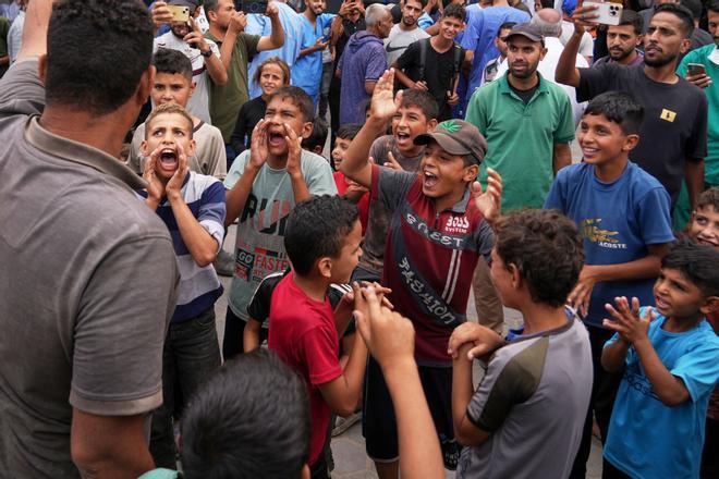 Palestinians celebrate following the announcement that Israel and Hamas have agreed to the first phase of a peace plan to pause the fighting, outside Al-Aqsa Hospital in Deir al-Balah, central Gaza Strip, Thursday, Oct. 9, 2025. (AP Photo/Abdel Kareem Hana)