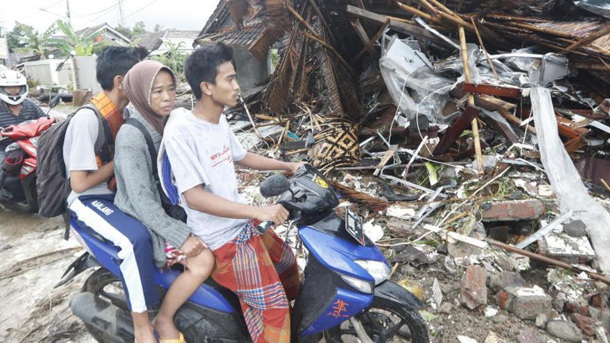 Residentes locales cerca de los escombros después del tsunami.