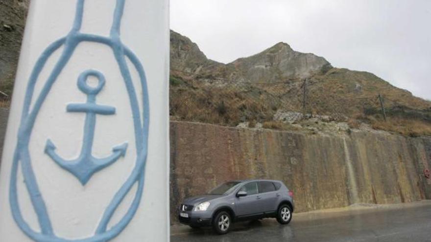 Un coche pasa junto a uno de los argayos de la ladera de Pinos Altos, frente a la entrada al Museo de Anclas.