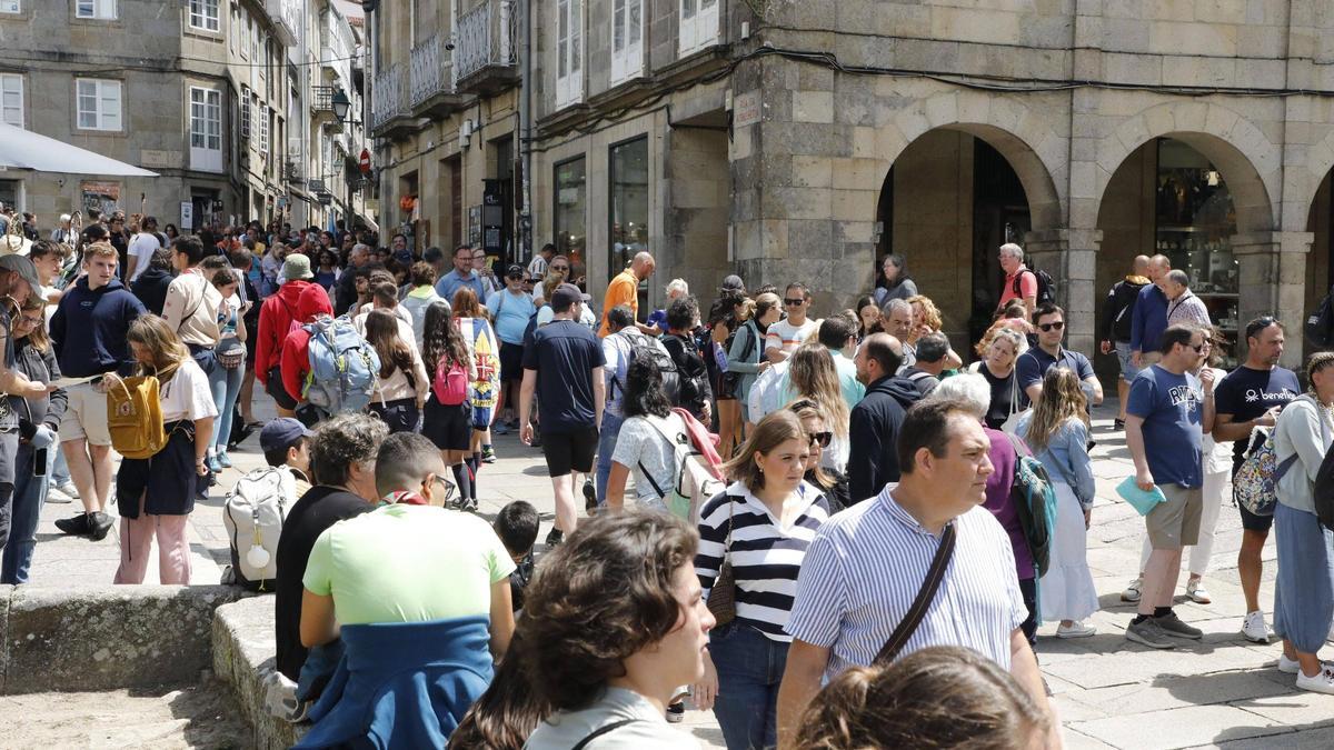 Turistas y peregrinos caminando por las calles de la zona vieja de Compostela