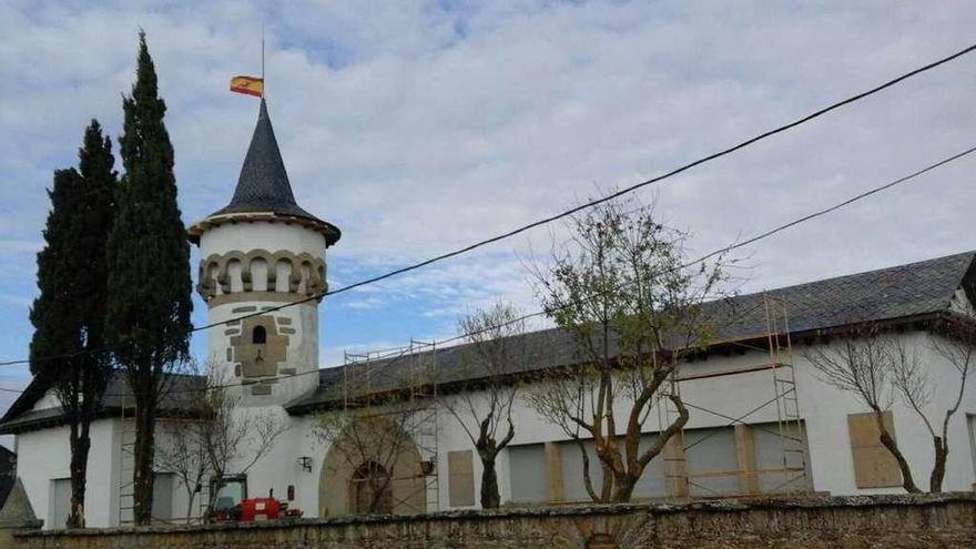 La bandera de España luce en la torre del taller de bordados, en plena restauración.