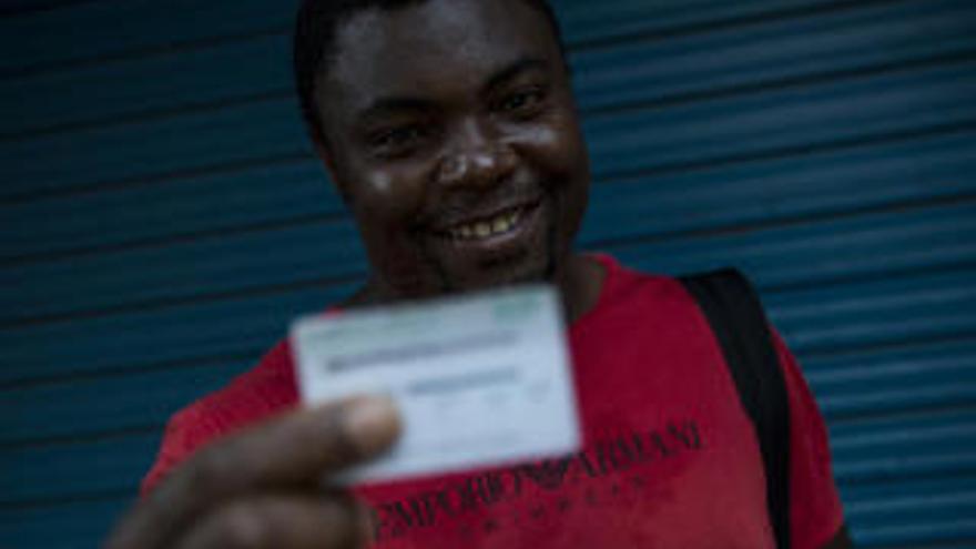 Un inmigrante recibe la tarjeta sanitaria.