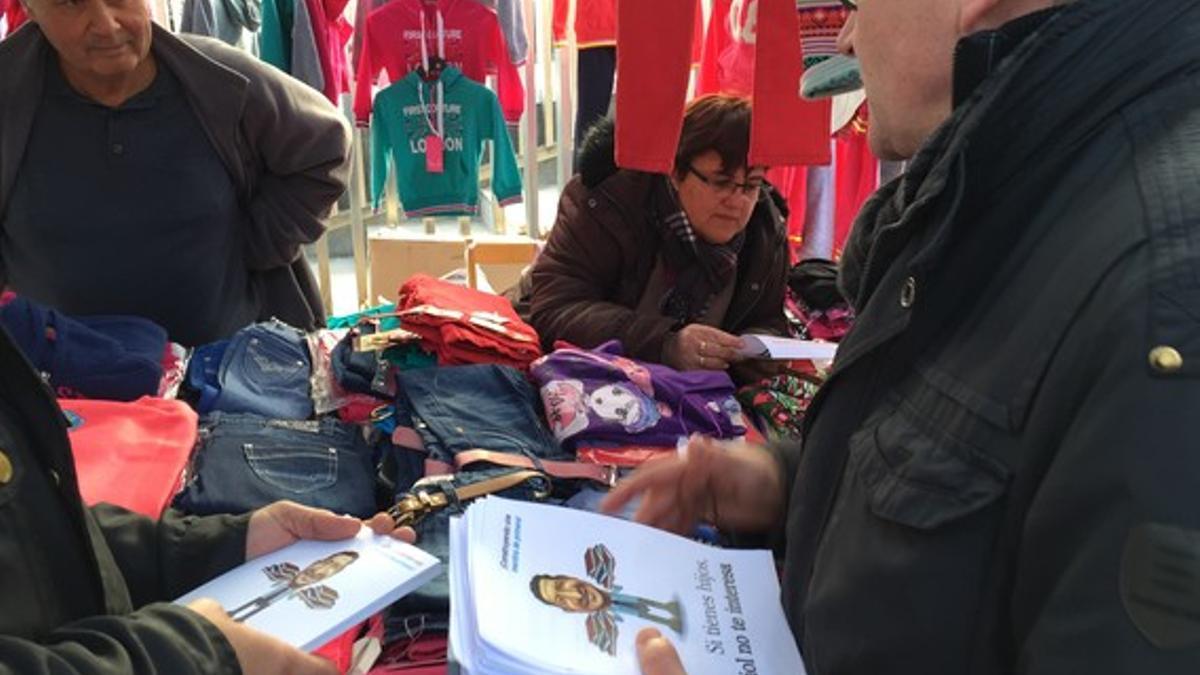 El concejal de CiU, Ferran Falcó, repartiendo hojas con el lema 'Si tienes hijos, Albiol no te interesa' en el mercado de La Salut de Badalona, el pasado miércoles.