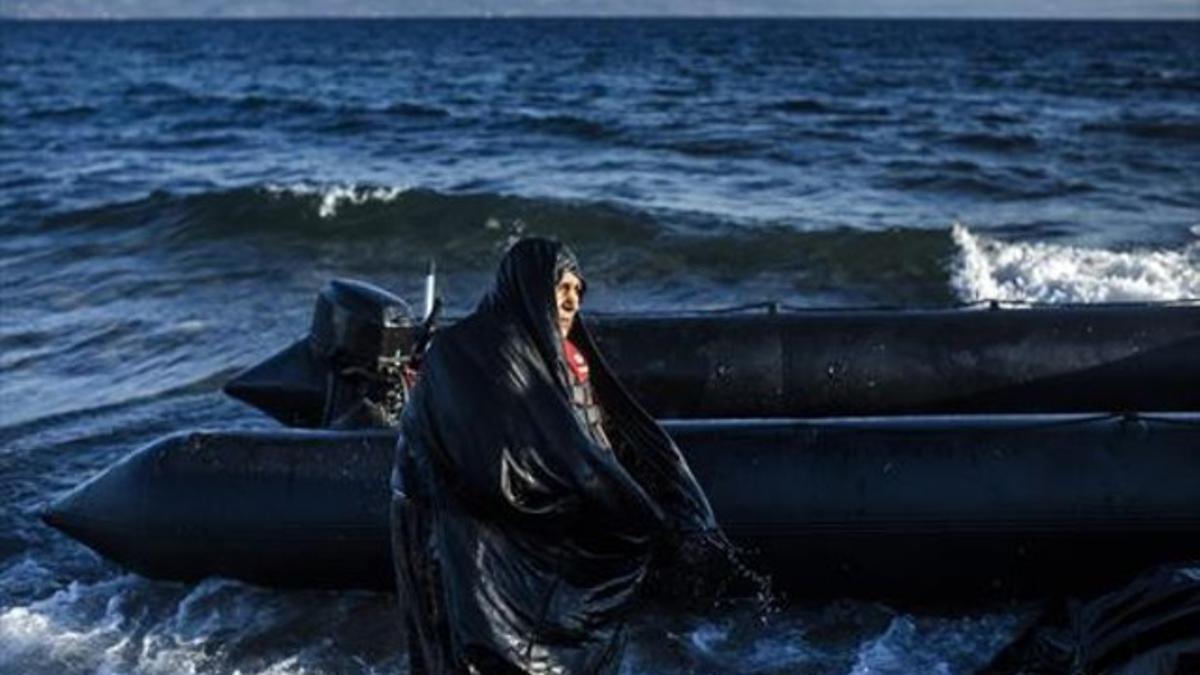 Una anciana con la ropa mojada desembarca en la isla de Lesbos tras cruzar el mar desde Turquía, este jueves.