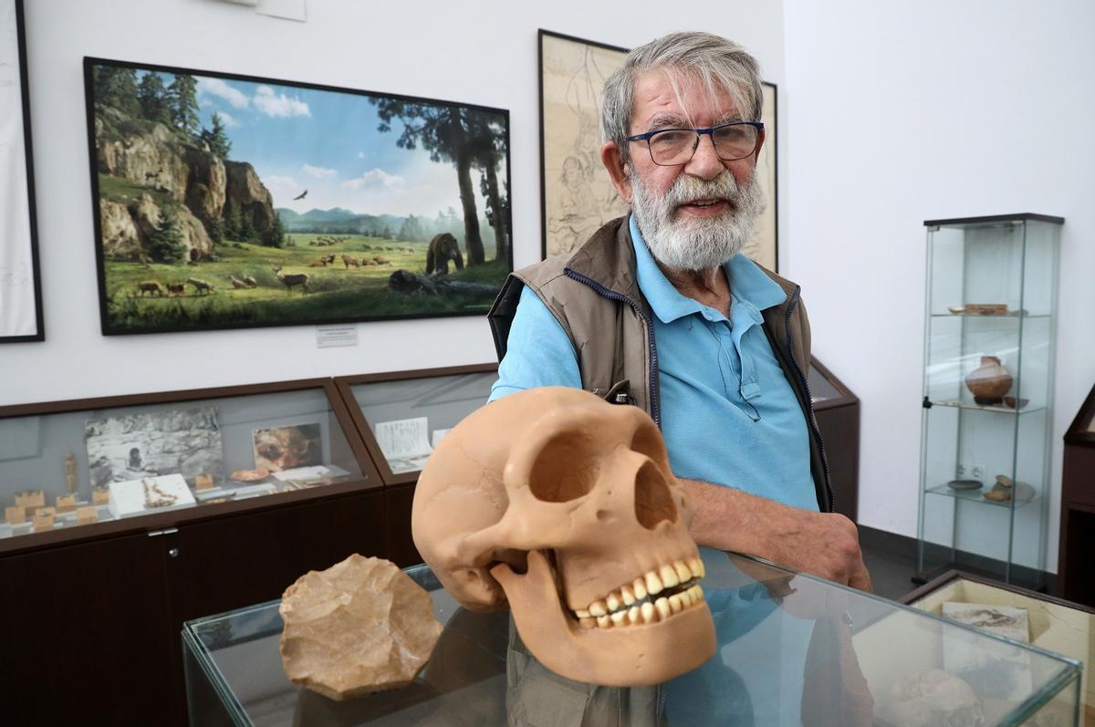 El arqueólogo Julián Ramos, esta semana, con la reproducción de un cráneo de neandertal y una piedra de sílex localizada en La Araña, empleada para hacer lascas.
