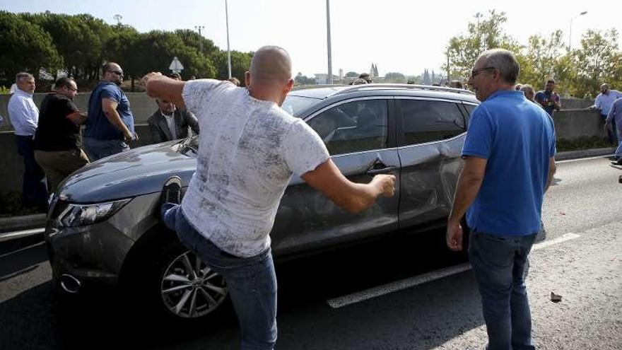 Un taxista patea el coche de un conductor de Uber, ayer, en Lisboa. // Efe