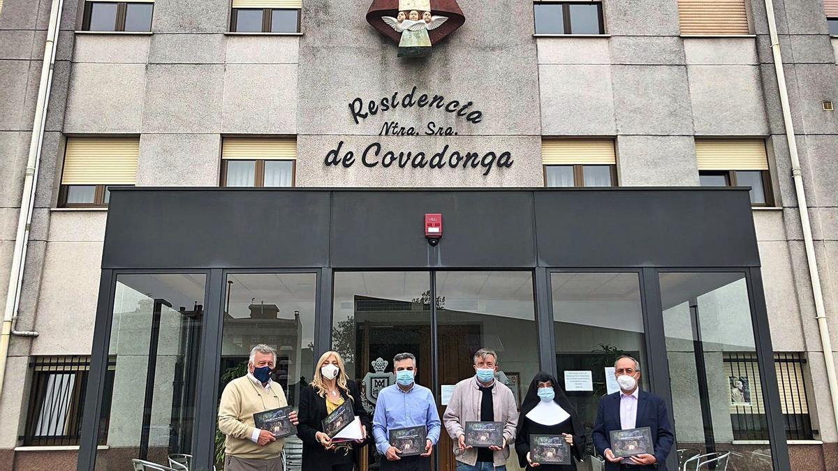 Por la izquierda, Miguel Ángel Fuente, editor del libro; Aurora Cienfuegos, concejala de Cultura; Pedro Noval, presidente del patronato Florencio Rodríguez; Fermín Riaño, capellán de Pola; sor Soledad, directora del asilo, y Ricardo Junquera, editor del libro, en la presentación de la obra, frente al Asilo de Ancianos de Pola de Siero. | I. G.