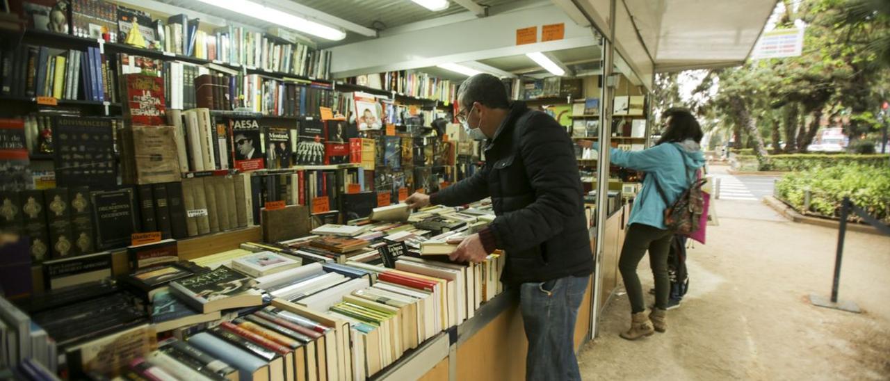 Un hombre mira un libro en la Feria del libro antiguo y de ocasión.