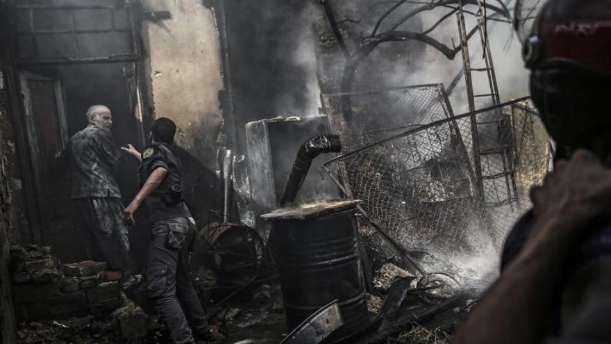 Bomberos apagan un fuego por un ataque aéreo, en Douma.