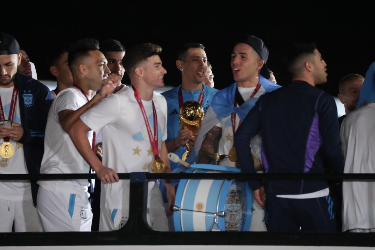 Ángel di María (c) de la selección argentina de fútbol sostiene el trofeo del Mundial de Fútbol Qatar 2022 a su llegada hoy, al Aeropuerto Internacional de Ezeiza a unos 22km de Buenos Aires (Argentina). EFE/ Raúl Martínez