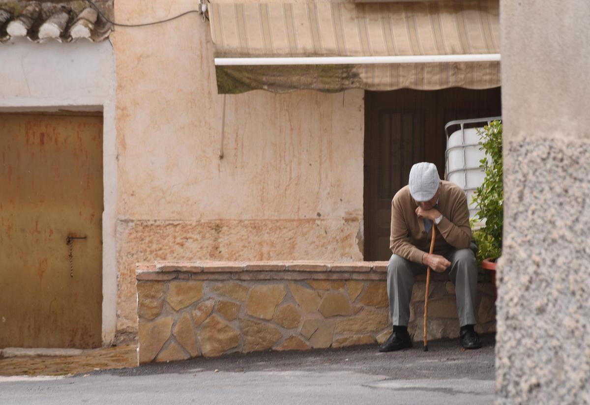 Foto de archivo de un hombre sentado en un pueblo.