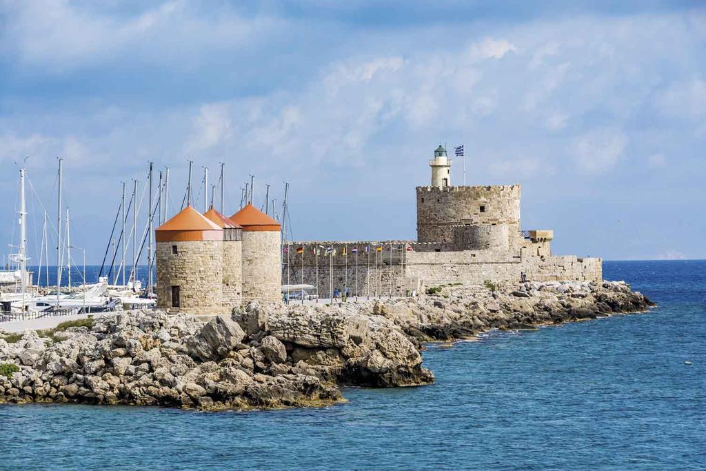 Molinos de viento y, al fondo, el fuerte y faro de San Nicolás.