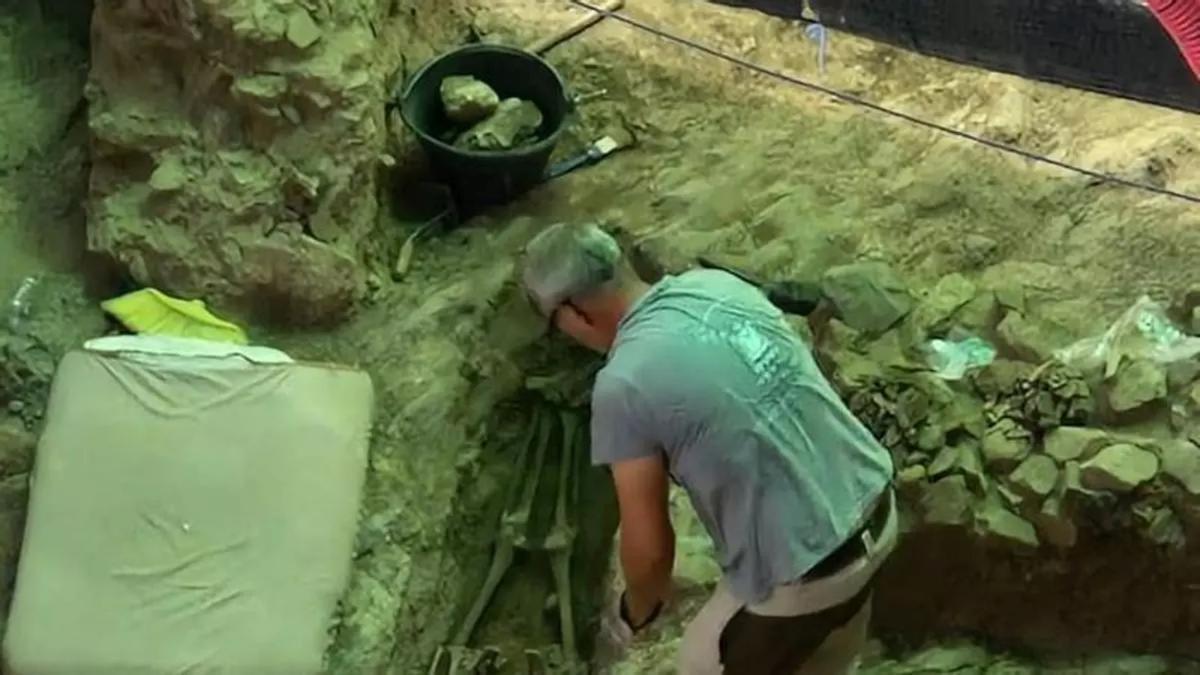 Un arqueólogo trabaja junto a uno de los enterramientos localizados durante la excavación en una vivienda de Mérida.