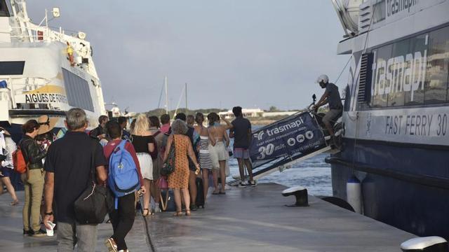 Pasajeros esperan para embarcar en un barco de la línea pitiusa, este verano en el puerto de la Savina. | D.I.