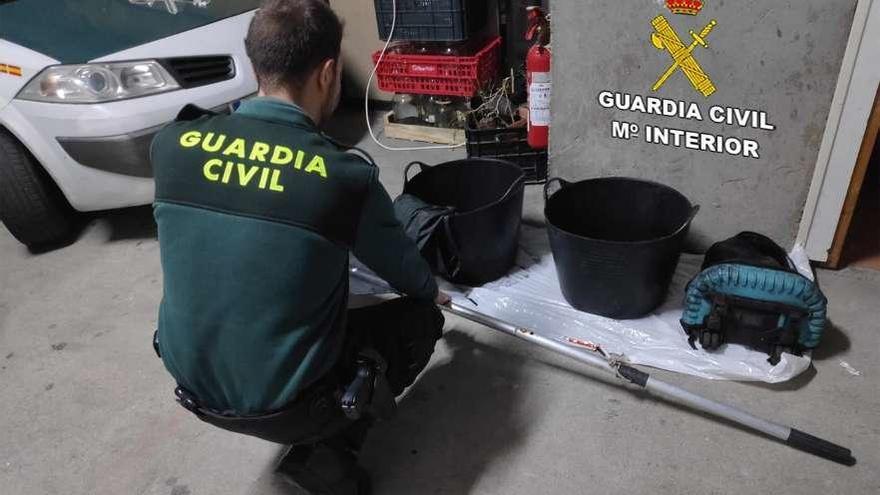 La Guardia Civil con los objetos incautados al presunto furtivo en Beluso. // Guardia Civil