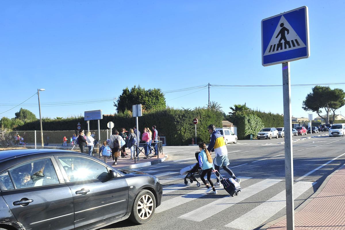 Un padre cruza la carretera con sus hijos por el paso de peatones, donde ya ha habido atropellos.