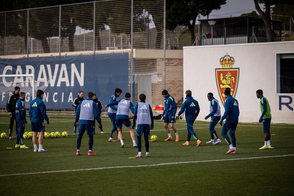 Los jugadores zaragocistas, en el rondo inicial del entrenamiento este lunes.