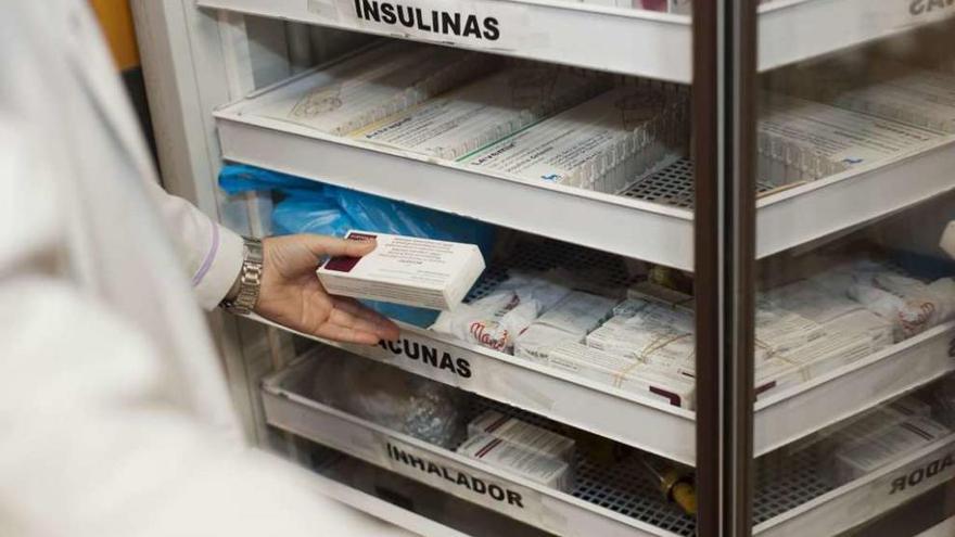 Una farmacéutica guarda una caja de la vacuna contra la meningitis B.