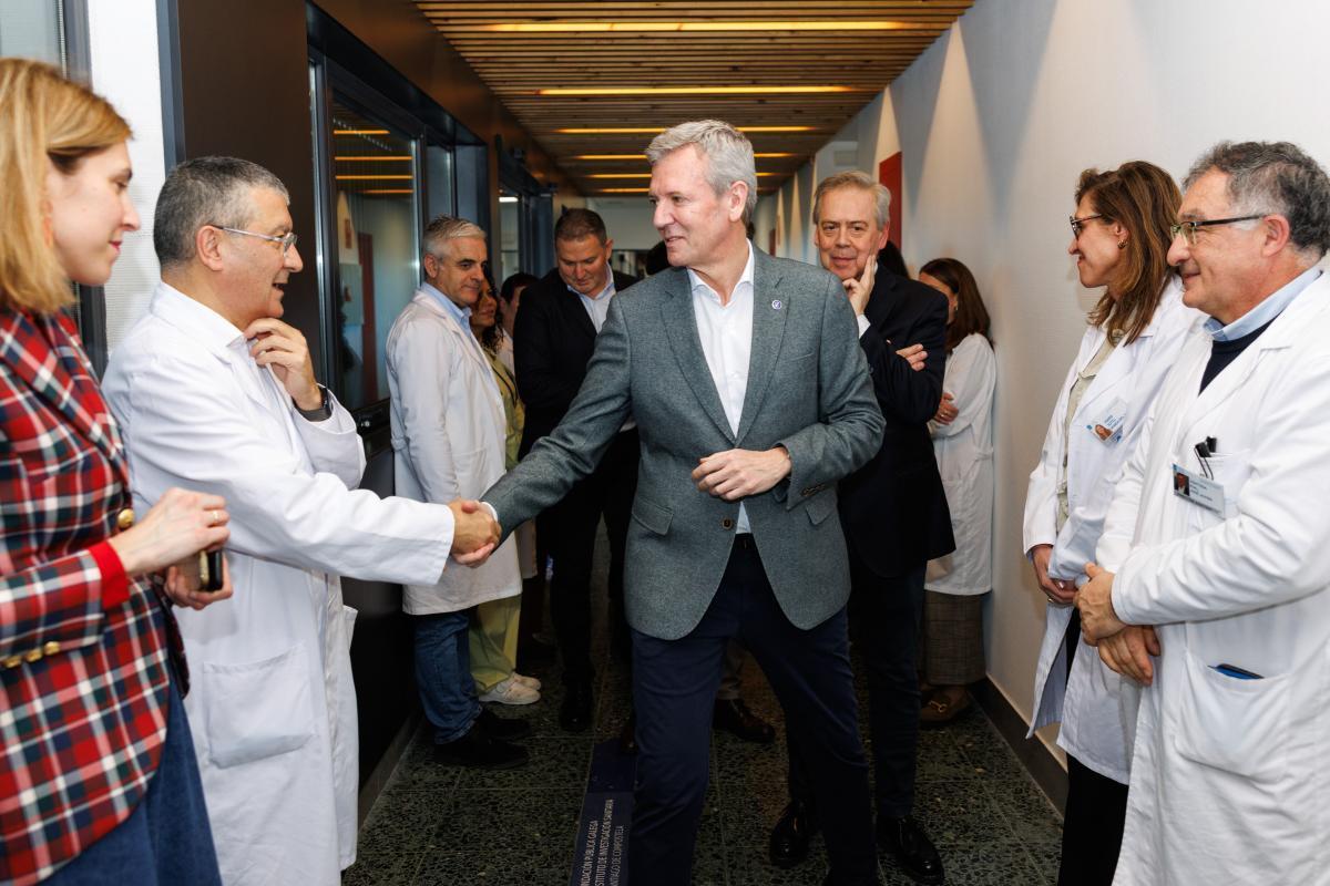 El presidente de la Xunta saluda al jefe de Oncología del CHUS durante su visita a la nueva sala de espera del Clínico de Santiago para pacientes con cáncer.